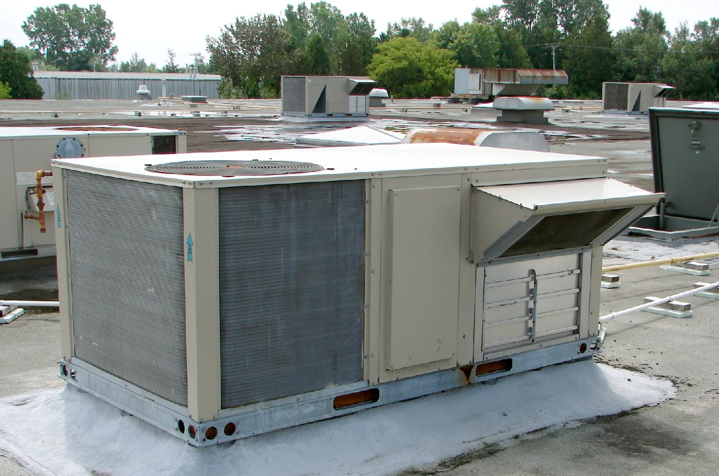 Rooftop packaged air conditioning unit with condenser coil and fresh air intake